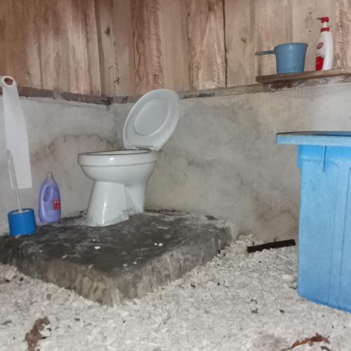 a bathroom with a toilet and a blue table at Or Mandira Homestay in Pulau Penemu