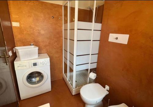 a bathroom with a washing machine and a washer at L'Angulin in Vezzo