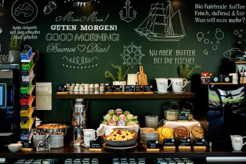 a coffee shop with a counter with food on it at Motel One Hamburg-Alster in Hamburg