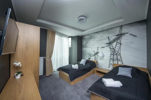 Un dormitorio con 2 camas y una pared con una foto. en Apartamenty D20 en Rybnik