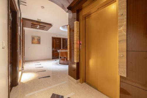 a hallway with a yellow door and a table at Hotel Aura - 05 Mins from New Delhi Railway Station & Connaught Place in New Delhi