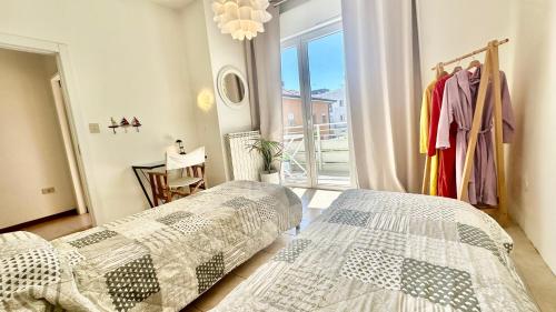 a bedroom with two beds and a large window at Ca' Adriana in Lido di Jesolo