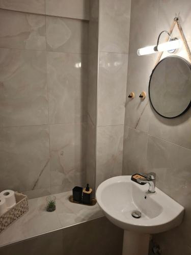 a white bathroom with a sink and a mirror at Foteini Rooms in Skala Sotiros