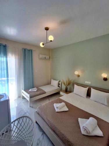 a large bedroom with two beds and a couch at Foteini Rooms in Skala Sotiros