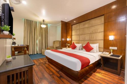 a hotel room with a large bed with red pillows at Hotel Aura - 05 Mins from New Delhi Railway Station & Connaught Place in New Delhi