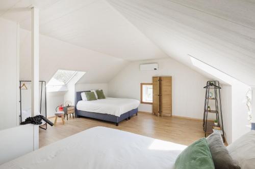 a bedroom with a bed and a ladder in a attic at Huisje aan de Schelde in Spiere