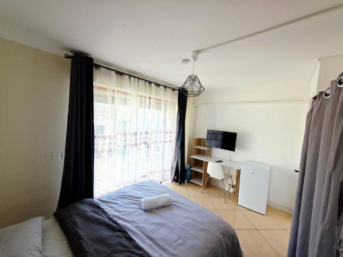 a bedroom with a bed and a window with a desk at Chambre B1 in Toulouse
