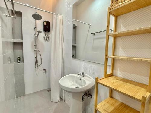 a white bathroom with a sink and a shower at La Casa Bella in Ban Nong Chaeng