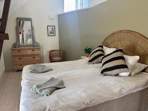 a bedroom with a large white bed with black and white pillows at Gårdsfrun in Löttorp