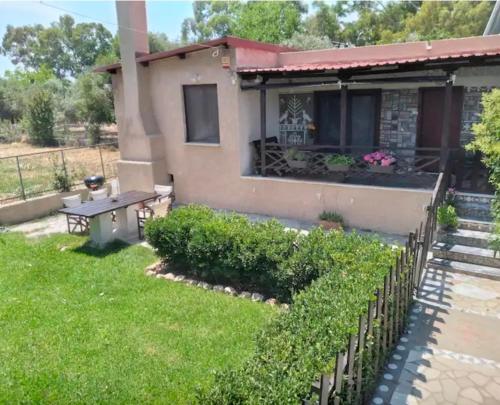 a house with a fence in the yard at Marathon Βeach Ηouse in Panayía Mesosporítissa