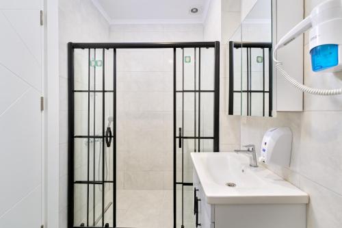 a bathroom with a shower and a white sink at Annabella Residence in Alanya