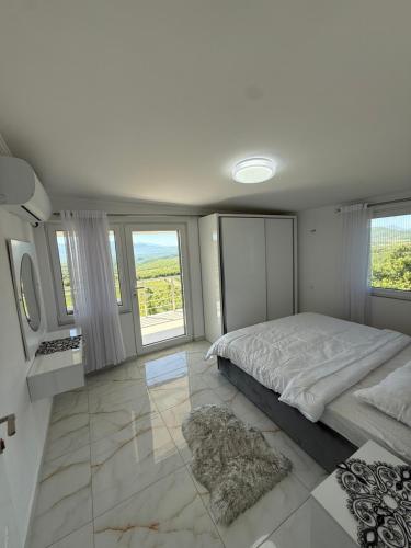 a bedroom with a large bed and large windows at Panorama Helshan Hotel in Helshan