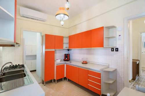 a kitchen with orange cabinets and a sink at Seaside House in Paestum
