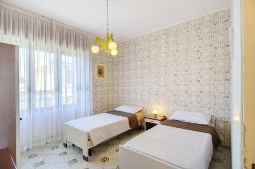 a bedroom with two beds and a window at Seaside House in Paestum