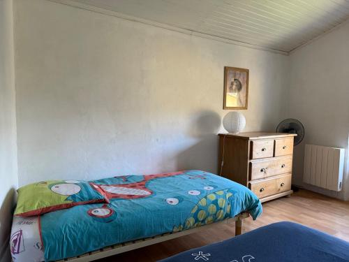 a bedroom with a bed and a dresser at Ma maisonnette en Cévennes in Le Vigan