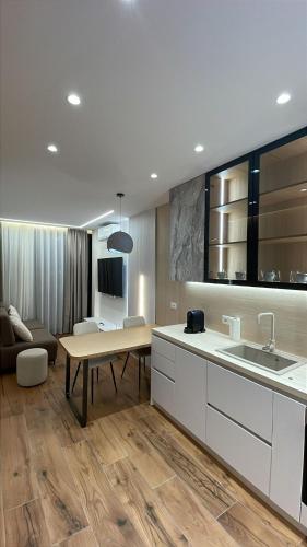 kuchnia ze zlewem, stołem i kanapą w obiekcie Palm Suites we Wlorze