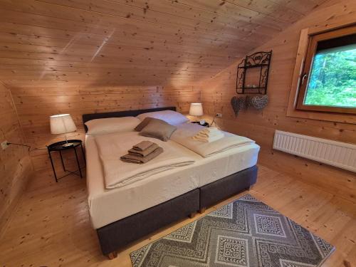 a bedroom with a large bed in a wooden cabin at Seewaldhüttn in Oberaichwald