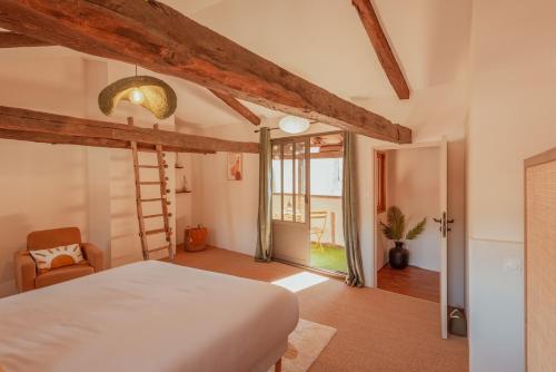 a bedroom with a white bed and a ladder at Maison POHESY in Figeac