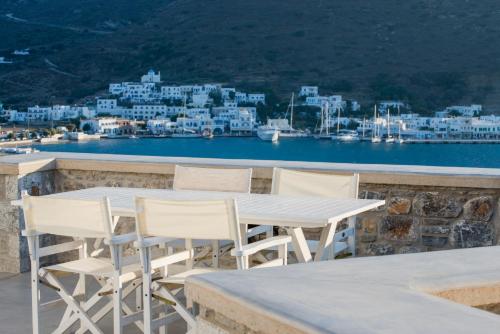 a table and chairs on a balcony with a view of a city at Kaerati Apartments in Katapola
