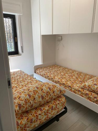 two beds in a small room withermottermottermott at SeaYouSoverato Apartment in Soverato Marina