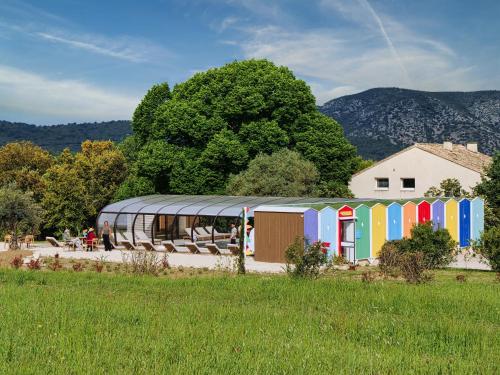 a building with a tent in a field at Hôtel et SPA des sources du gros noyer in Malaucène