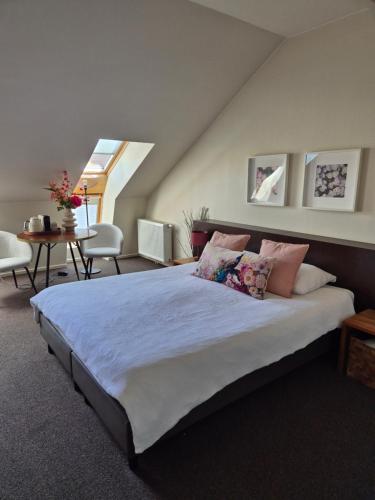 a bedroom with a large bed with pillows at Boutique Hotel De Raetskamer in Noordwijkerhout