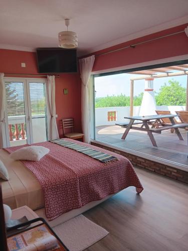 a bedroom with a bed and a large window at Alojamento local Patudos, Suite com terraço privado in Tavira