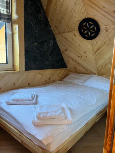 a bed in a wooden room with towels on it at Apartamenty pod Tatrami in Zakopane