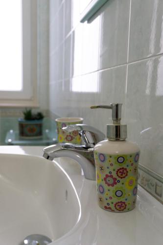 a soap dispenser sitting on a bathroom sink at Nosside & Saffo Guesthouse in Amantea