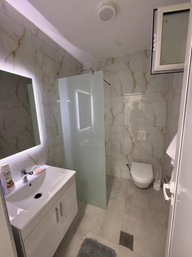 a bathroom with a sink and a shower and a toilet at Panorama Helshan Hotel in Helshan