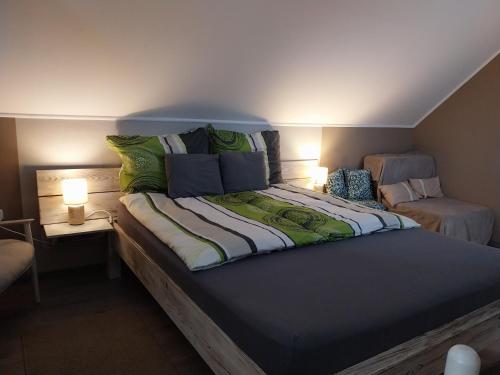 a large bed in a room with two lamps at Kovács Vendégház in Bük