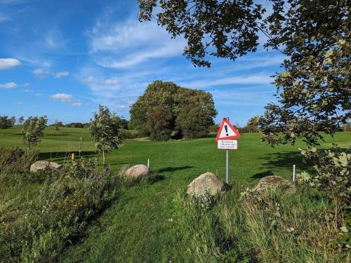 a yield sign in a field with rocks at 4 person holiday home in Aabenraa in Aabenraa