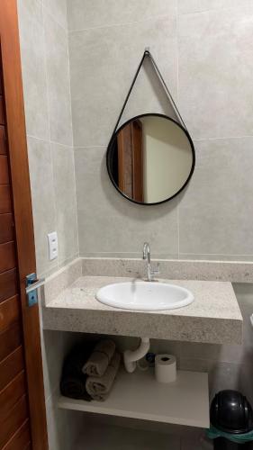 a bathroom with a sink and a mirror on the wall at Casa nova, confortável e funcional em Redação-PA in Redenção