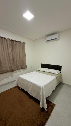 a white room with a bed and a window at Casa nova, confortável e funcional em Redação-PA in Redenção