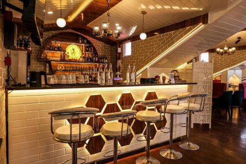 a row of stools at a bar in a restaurant at Hotel Shaurrat in Shimla