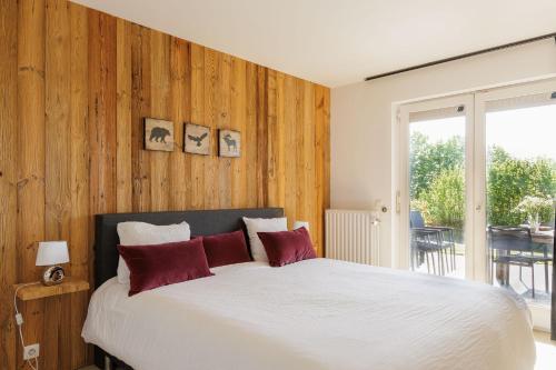 a bedroom with a large white bed with red pillows at Het Kastanjehuis in Orlitain