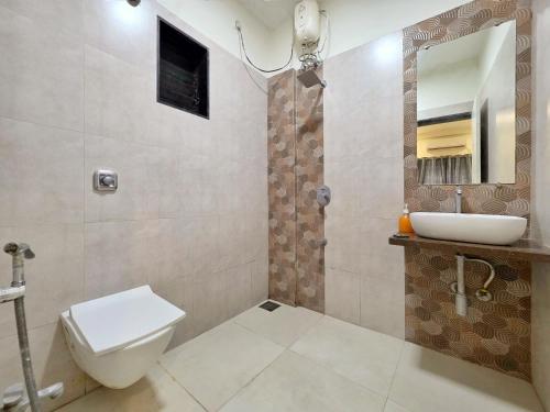 a bathroom with a toilet and a sink and a mirror at JAGUAR VILLA II 3BHK II AC II POOL Il EMPYREAN STAY in Lonavala