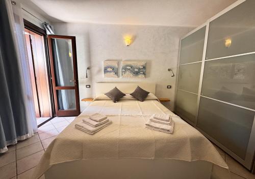 a bedroom with a bed with two towels on it at Crisalide in La Maddalena