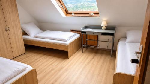 a small room with two beds and a window at Basic Work Stay Rooms - Highspeed WiFi - Easy Self Check-In - Practical and Affordable Stay in Bürs