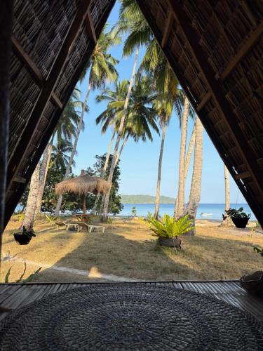 a view of the beach from a resort with palm trees at Lumindas Beach Resort in Sabang