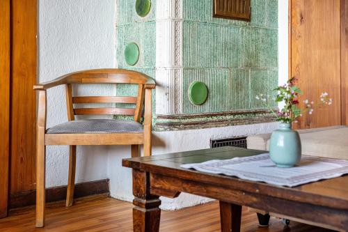 a chair and a table with a vase on it at Kleines Waldglück in Lenzkirch