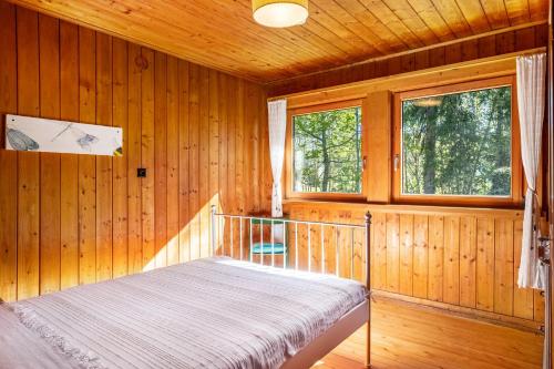 a bedroom with a bed in a wooden cabin at Kleines Waldglück in Lenzkirch