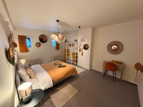 a bedroom with a bed and a desk in it at Capsule camelia un charme Montois in Mons