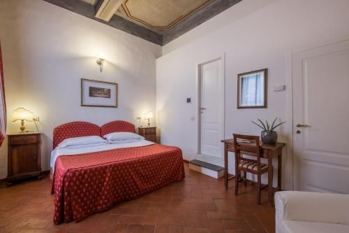 sypialnia z czerwonym łóżkiem, stołem i krzesłem w obiekcie B&B Home in Florence we Florencji