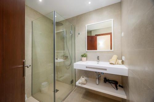 a bathroom with a sink and a glass shower at Cala Figuera Apartment 1b in Cala Figuera