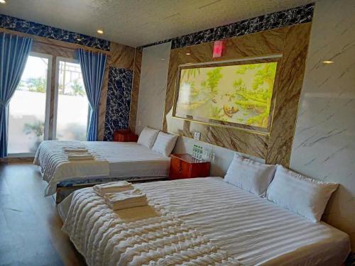 a bedroom with two beds and a window at Hotel View Sông Phú Quốc in Phú Quốc