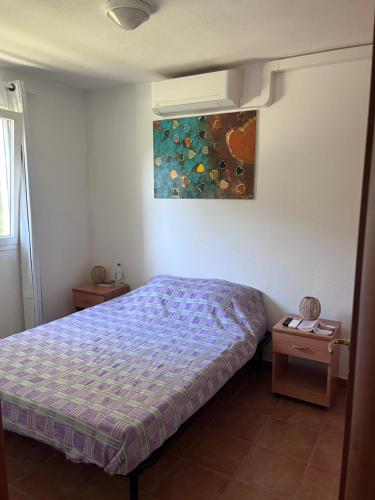 a bedroom with a bed and a painting on the wall at APPARTEMENT sognu di rena G1 in San-Nicolao