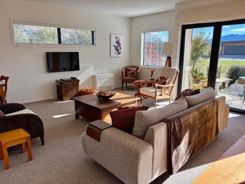 a living room with a couch and a tv at Alpine Abode in Wanaka