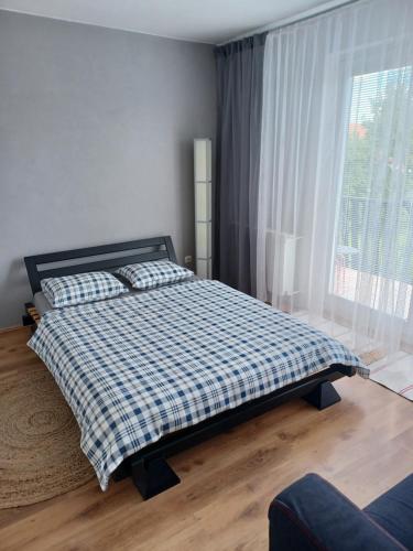 a bedroom with a bed and a large window at Apartmán Radenice in Radenice