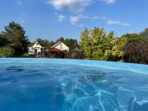 a pool of water with a house in the background at DIÓFA APARTMAN in Pilismarót
